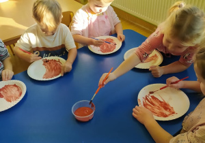 Malowanie farbami białych talerzyków.